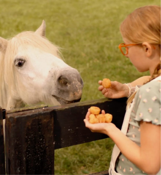 Girl feeding pony Pal's Cheddar Rounds