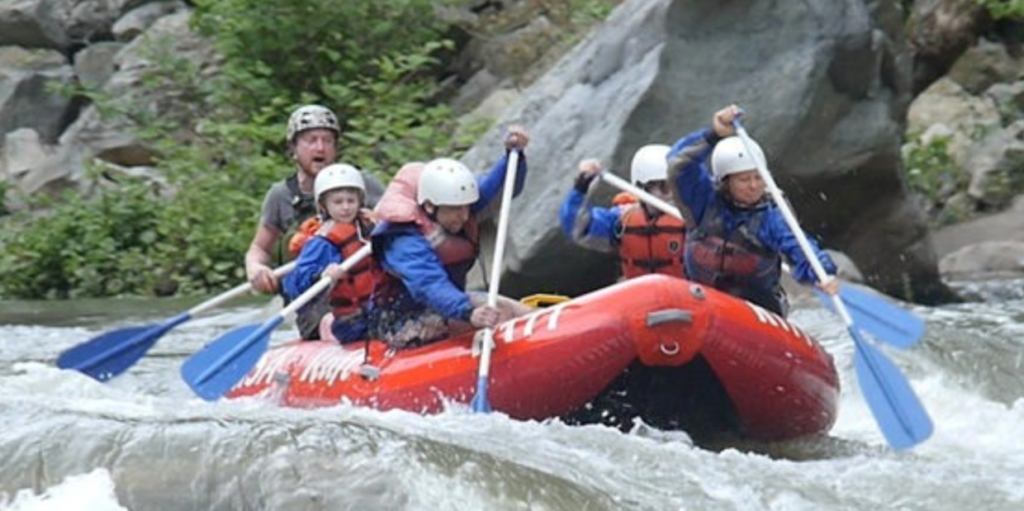 Excite group of whitewater rafters paddling down stream